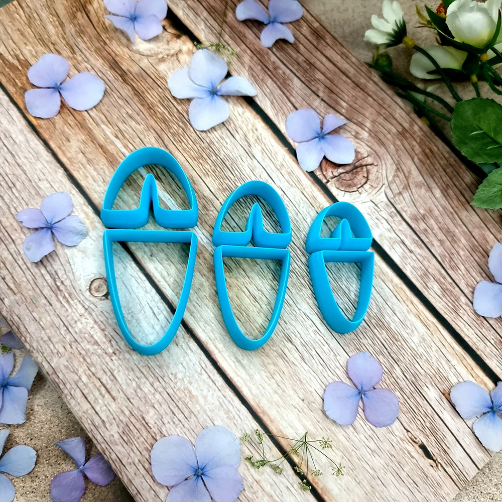 Blue PLA U-shape polymer clay cutters in three sizes cutting an arch band and tapered base, with finished plaid and floral clay pieces by SweetyBijou