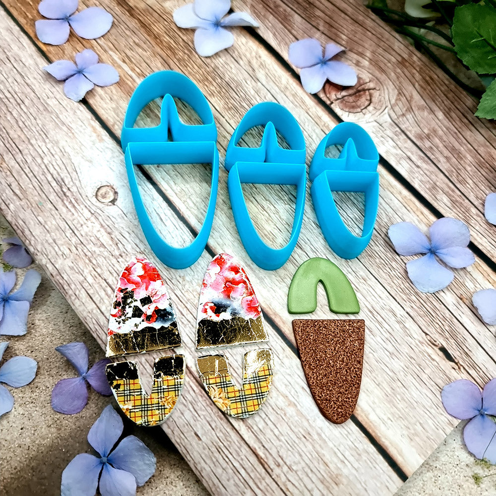 Blue PLA U-shape polymer clay cutters in three sizes cutting an arch band and tapered base, with finished plaid and floral clay pieces by SweetyBijou