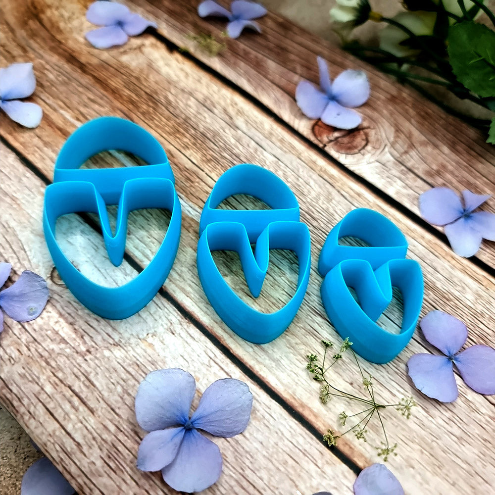 Blue PLA U-shape polymer clay cutters in three sizes cutting a dome cap and U piece, with leopard, plaid and marbled clay pieces by SweetyBijou