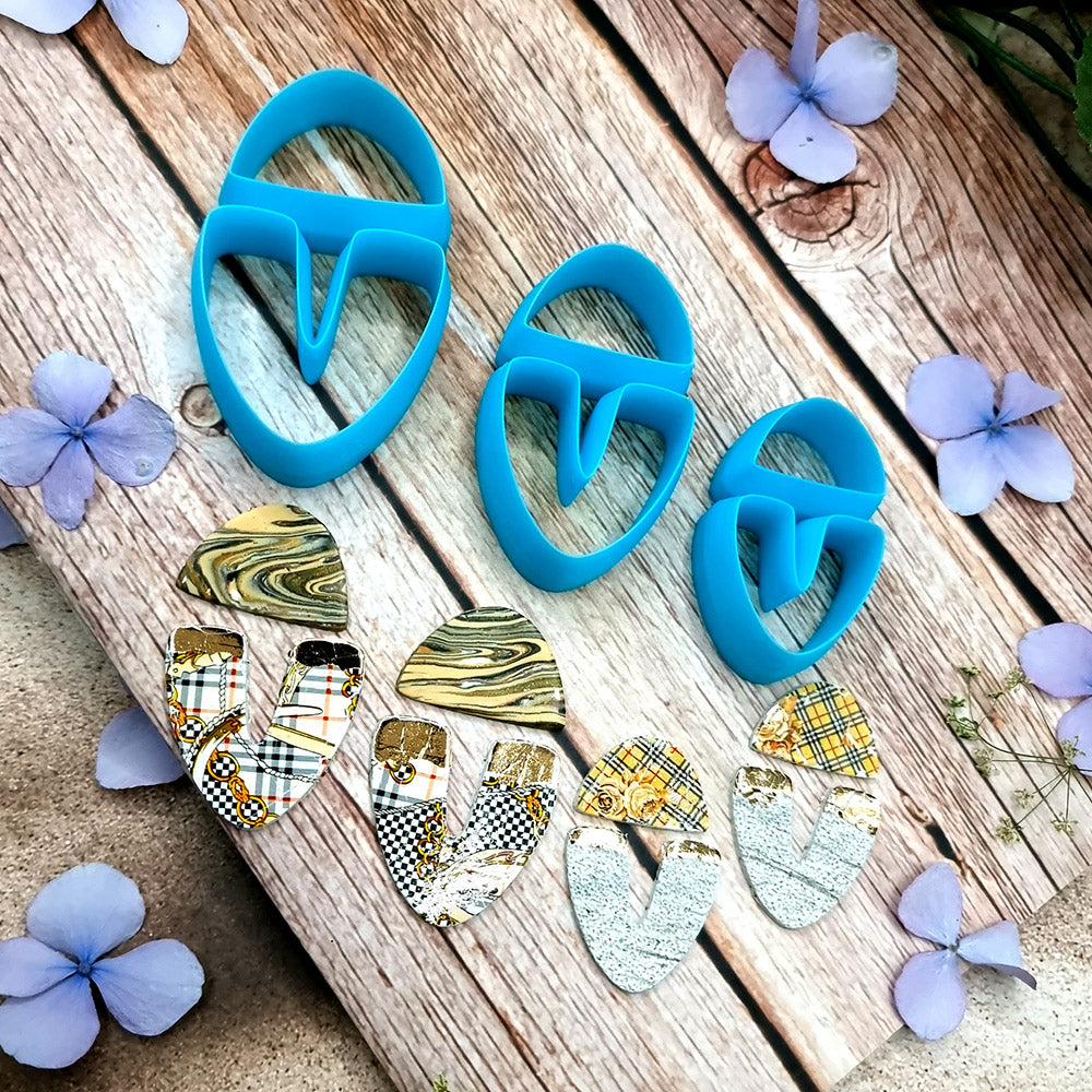 Blue PLA U-shape polymer clay cutters in three sizes cutting a dome cap and U piece, with leopard, plaid and marbled clay pieces by SweetyBijou