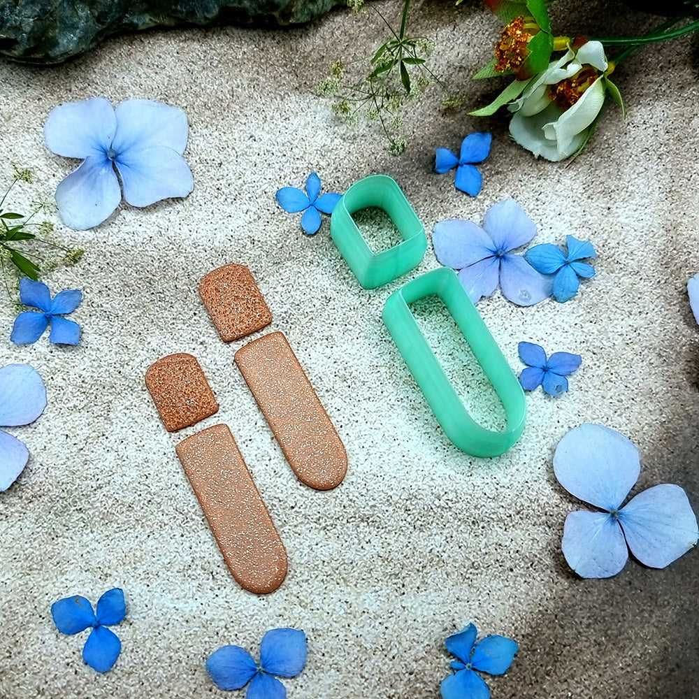 Green PLA stacked bar polymer clay cutter that cuts a small stud and a long rounded bar, with terracotta clay earring pieces by SweetyBijou