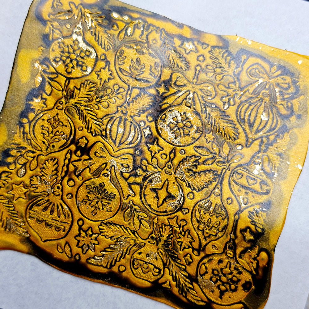 Polymer clay sheet textured with the Christmas Ornaments Christmas texture plate