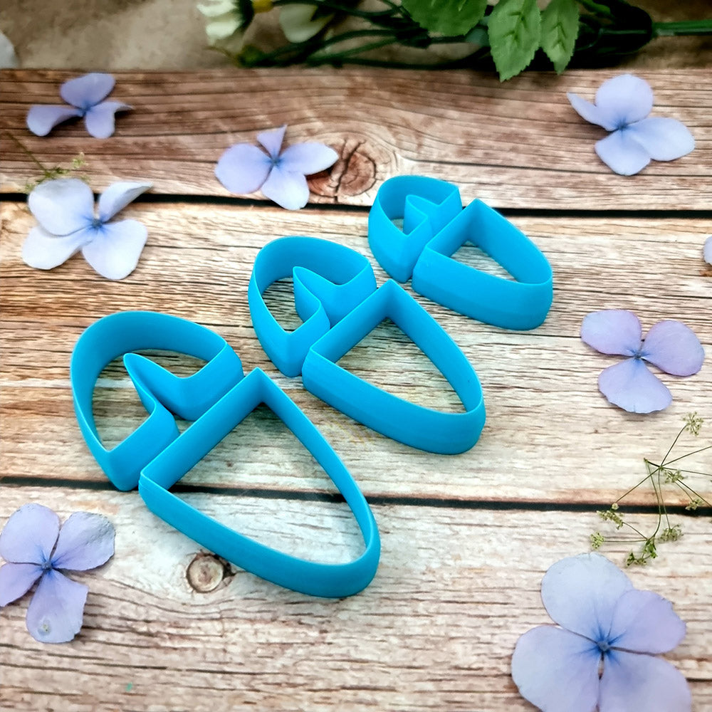 Blue PLA U-shape polymer clay cutters in three sizes cutting an arch band and tapered base, with finished plaid and floral clay pieces by SweetyBijou