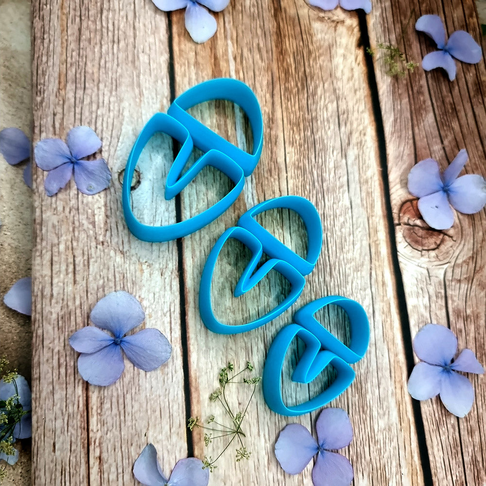 Blue PLA U-shape polymer clay cutters in three sizes cutting a dome cap and U piece, with leopard, plaid and marbled clay pieces by SweetyBijou