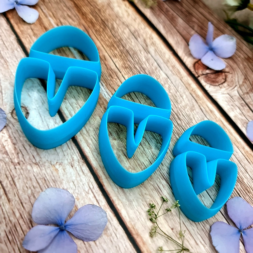 Blue PLA U-shape polymer clay cutters in three sizes cutting a dome cap and U piece, with leopard, plaid and marbled clay pieces by SweetyBijou